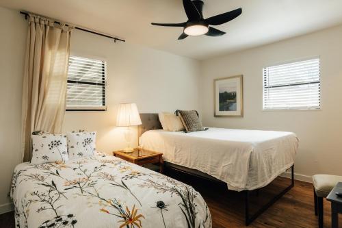 a bedroom with two beds and a ceiling fan at Extended Stay SoCo Oasis Outdoor TV, Heavenly Bed, Long Stay Ready in Austin