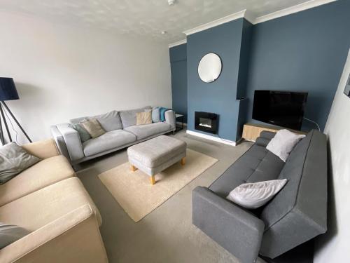 a living room with a couch and a tv at Spacious 5-Bedroom Home with Garden & Parking Near Station in Coventry