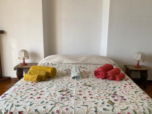 a bed with three different colored pillows on it at B&B Luci del porto in Genoa