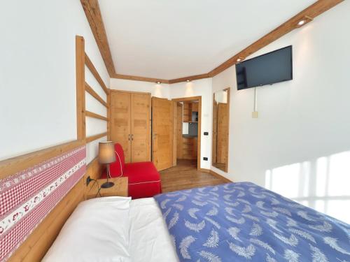 a bedroom with a bed and a flat screen tv at Cesa Dolomia Apartments in Canazei