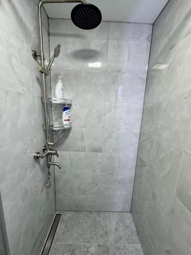 una doccia in un bagno con parete piastrellata di Apartament Edinet a Edineţ