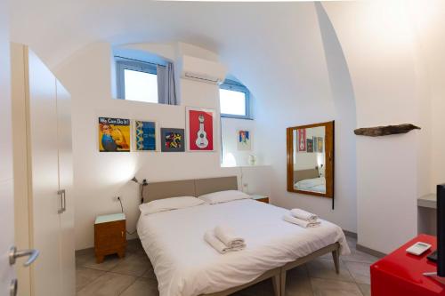 a bedroom with a bed with white sheets and a mirror at CasaCirio Agriturismo in Rialto
