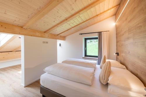 two beds in a room with wooden ceilings at Residence Bosco Verde in San Cassiano