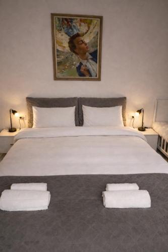 a bedroom with a large white bed with two pillows at Boheme Studio in Timişoara