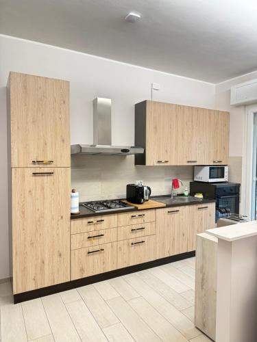 a kitchen with wooden cabinets and a stove top oven at Rosy Bed&Breakfast in Terni