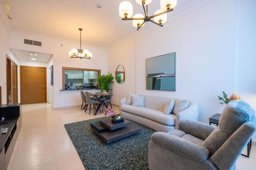 a living room with two couches and a table at Yas Island 1BR - Chic Luxe Retreat in Abu Dhabi