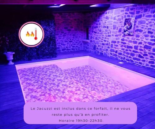 a bath tub in a room with a sign at Jacuzzi XXL avec La Rouyonnaise in Tinténiac