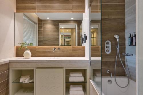 a bathroom with a sink and a shower at Atlantica Aegean Blue in Kolymbia
