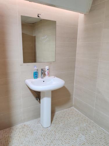 a bathroom with a white sink and a mirror at King bed sea view in Sharjah