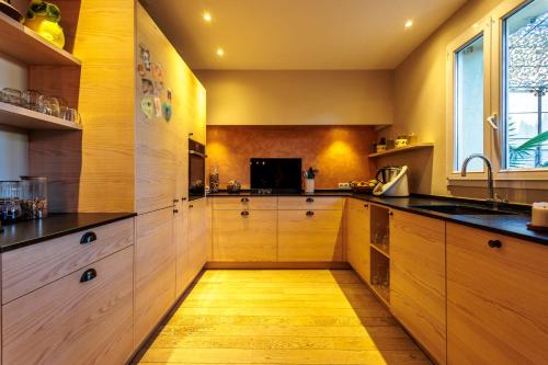 a kitchen with wooden cabinets and a wooden floor at Maison Flammarion - Welkeys in Avignon