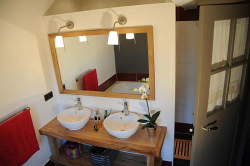 a bathroom with two sinks and a large mirror at Le refuge de théoline in Lathus St Remy