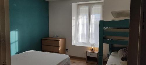 a bedroom with two bunk beds and a window at Les lilas in Lhommaizé