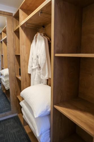 a walk in closet with white clothes and pillows at Hotel Radan Prolom Banja in Prolomska Banja