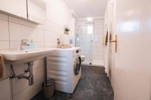 a white bathroom with a sink and a washing machine at Gemütliches Nest in Rinkerode in Drensteinfurt
