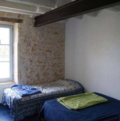 a bedroom with two beds and a window at Le gîte de la roche in Antigny