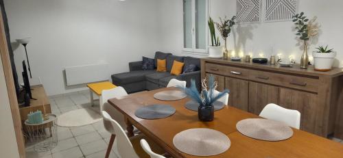 a living room with a table and a couch at Maison familiale tout équipée in Dunes