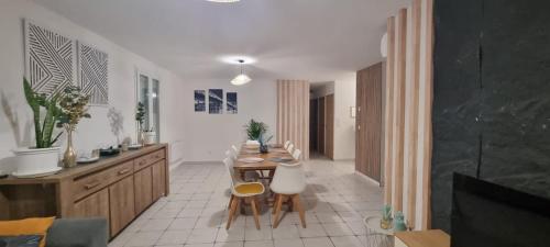 a kitchen with a table and chairs in a room at Maison familiale tout équipée in Dunes