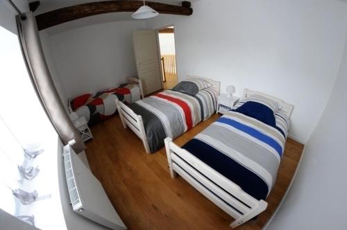 a group of three beds in a room at Gîte de la tonnelle in Saint-Georges-lès-Baillargeaux