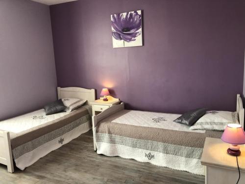 two beds in a room with purple walls at L'althéa in Saint-Gervais-les-Trois-Clochers