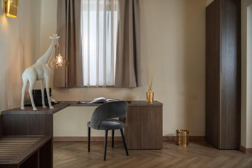 a desk with a chair and a giraffe statue on it at Just Hotel Saronno in Saronno