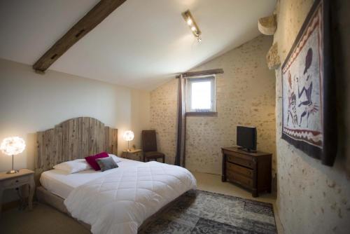 a bedroom with a white bed and a window at Le clos mélior in Lusignan