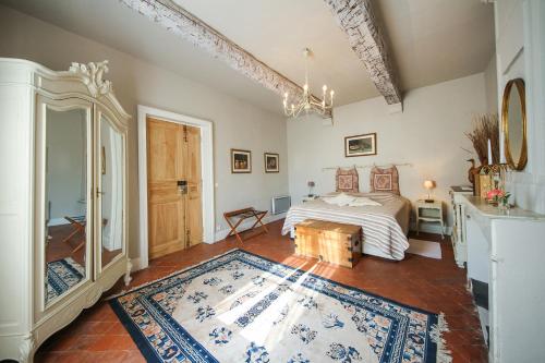 a bedroom with a bed and a rug in a room at Les Carmes and spa in Le Thor