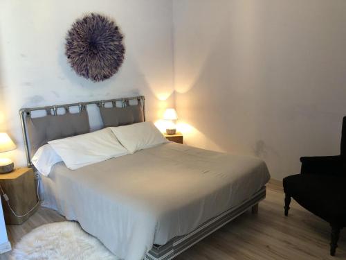 a bedroom with a bed and a chair and two lamps at Le clos constance in Yversay