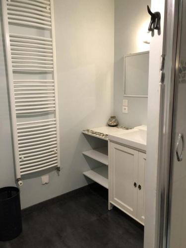 a white bathroom with a sink and a mirror at Le clos constance in Yversay