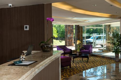 a lobby with a reception desk with a laptop on a counter at Falls Iguazú Hotel & Spa in Puerto Iguazú