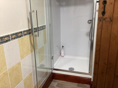 a bathroom with a shower with a glass door at Hops and the Vines in Shipston-on-Stour