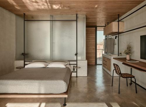 a bedroom with a bed and a desk and a kitchen at Dexamenes Seaside Hotel in Kourouta