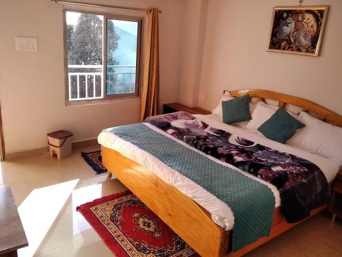 a bedroom with a bed and a window at Mount aura stay & Dine in Kanatal