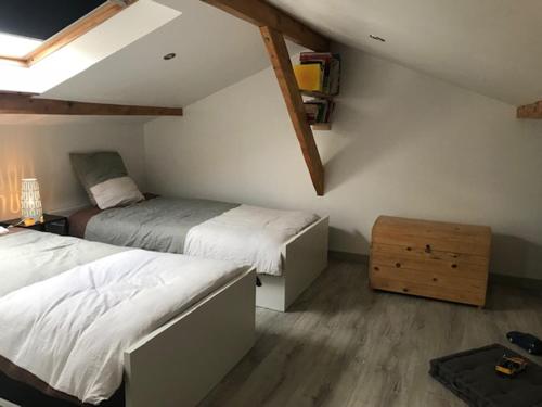 a bedroom with two beds and a dresser at Le chalet des forges in Mairé