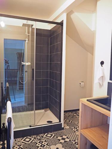 a bathroom with a shower with a glass door at Les tilleuls in Persac