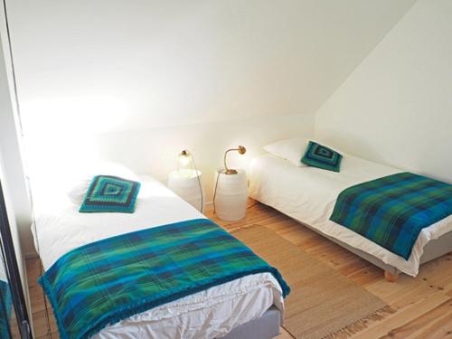 two beds sitting next to each other in a room at Les tilleuls in Persac