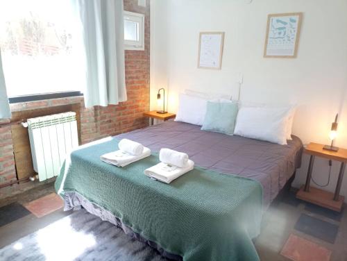 a bedroom with a bed with two towels on it at Posada San Antonio in El Chalten