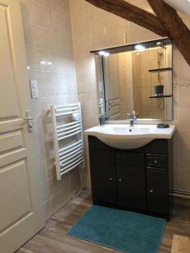 a bathroom with a sink and a mirror at La maison de gatienne in Coussay-les-Bois