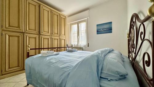 a bedroom with a large bed with blue sheets at Garage Privato Elegante Bilocale in Alassio