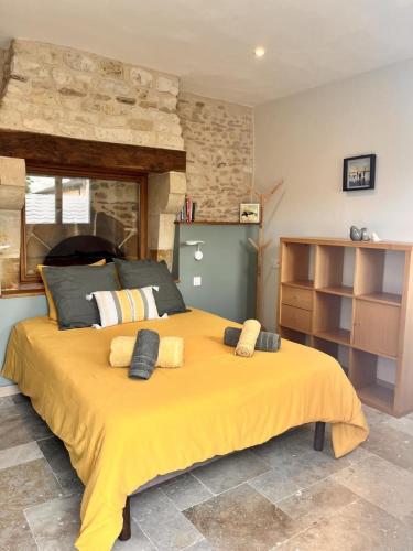 a large yellow bed with two pillows on it at Le chant du jau in Beaumont