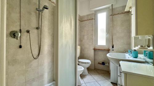 a bathroom with a shower and a toilet and a sink at Garage Privato Elegante Bilocale in Alassio