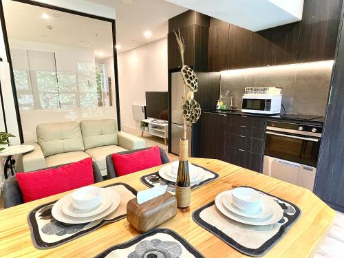a kitchen and living room with a wooden table and chairs at Modern apartment in the city center in Auckland