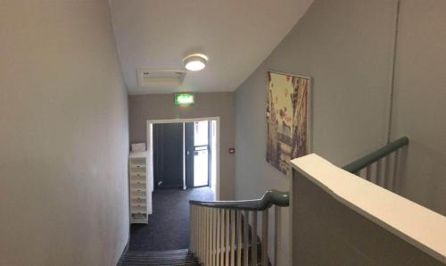 a hallway with a stairway with a door and a stair at Parsons Street in Dudley