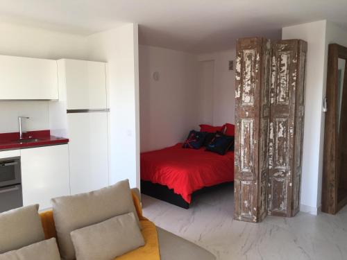 a bedroom with a bed with a red bedspread at Escale à Saint-Tropez in Saint-Tropez