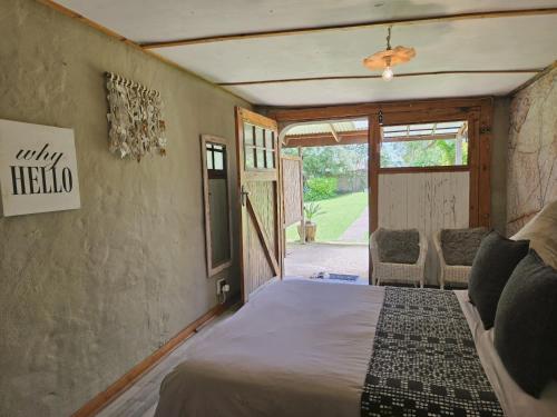 a bedroom with a bed and a door to a yard at Rustique in Graskop