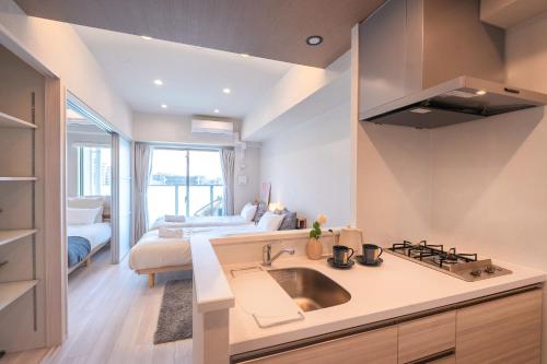 a kitchen with a sink and a bed in a room at AYA Residence大阪城公園 Osaka Castle JR Morinomiya 徒歩5min in Osaka