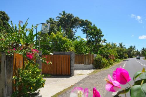 a street with pink flowers on the side of a road at Fare Maheata in Pihaena