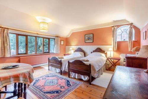 a bedroom with two beds and a table at 4 Bed in Walberswick oc-hfarm2 in Walberswick
