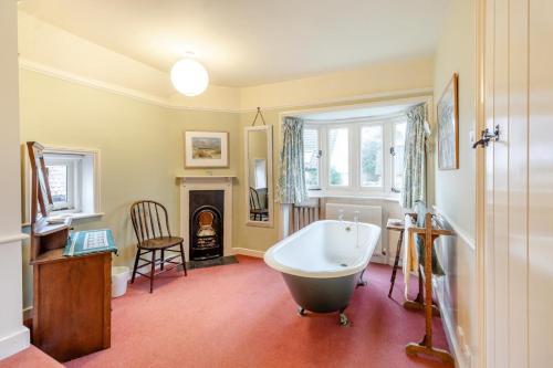 a bathroom with a bath tub and a fireplace at 4 Bed in Walberswick oc-hfarm2 in Walberswick