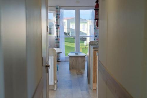 a hallway with a door leading to a living room at Sirocco Caravan in Westward Ho