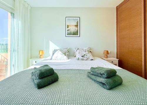 a bedroom with a bed with two green pillows on it at Calma Suite Apartment - Mar Menor Golf Resort in Torre-Pacheco